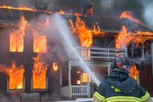 Feuerwehrmann löscht brennendes Haus