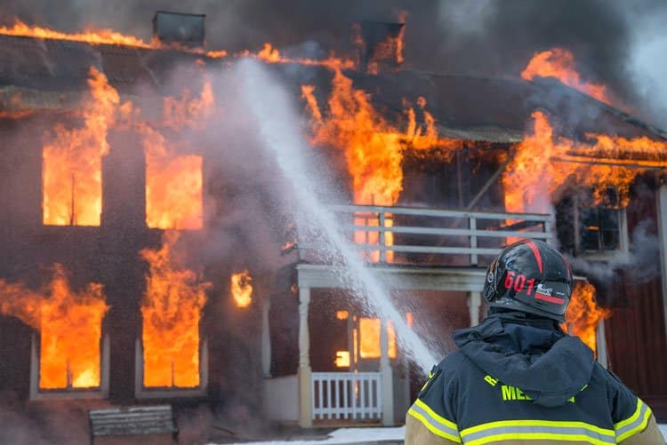 Feuerwehrmann löscht brennendes Haus